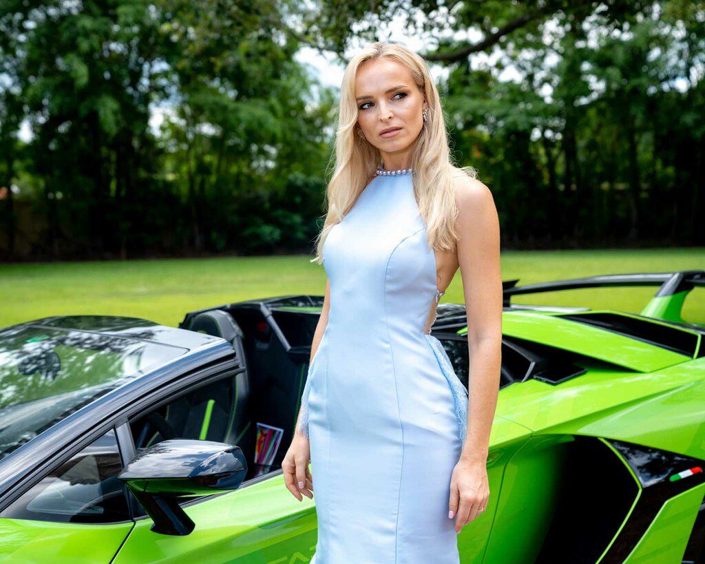 Gorgeous model is posing next to the green Ferrari.